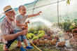 © ivanko80 - Grandfather with his grandson working in the garden