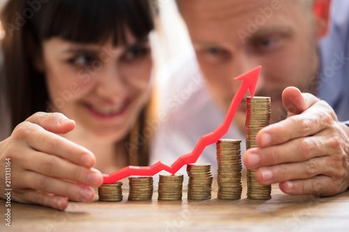 Fotografía Couple Protecting Increasing Stacked Coins