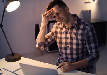 Canvas Print - Overworked man with headache in office