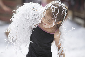 Little girl playing on nature with sliced paper