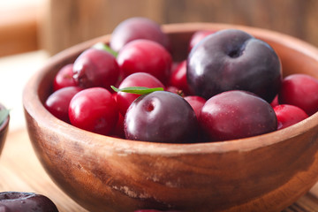 Bowl with ripe juicy plums, closeup