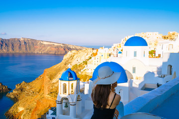 Canvas Print - Female tourist near famous blue domes in Santorini,Greece