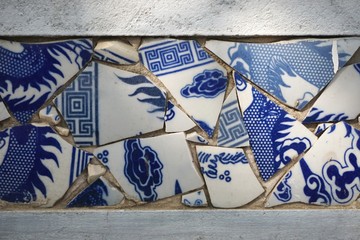 Broken blue and white china shards set in a wall