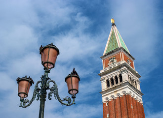 The bell tower of San Marco Campanile and the famous Venetian street lamp. Campanile located on St. mark's square in front of San Marco Cathedral. Venice, Italy