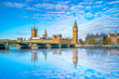 Big Ben and Westminster parliament with blue sky and water reflection