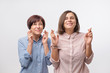 © Viktor Koldunov - Two women mother and daughter crossing fingers and wishing for good luck. Wishing to get a good news.