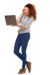 Wall Mural - Full length young woman smiling with laptop against isolated white background