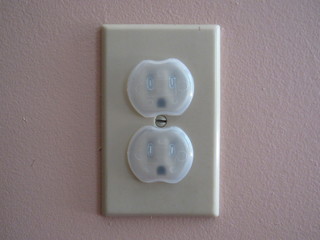 an american outlet with safety childproof outlet covers on them