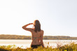 © Photoboyko - Beautiful slim woman enjoying a drink near lake at sunset of warm sunny afternoon. Young fit female drinking lemonade at river bank