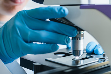 Wall Mural - scientist hands with microscope close-up shot in the laboratory