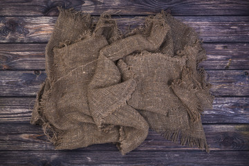 Wall Mural - Burlap on black wooden background, top view