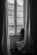 © Tetiana - Morning in Rome. Naked girl sitting near a large window wrapped in a curtain, black and white photo