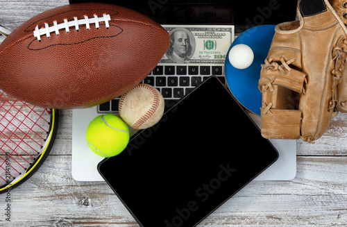 Fotografía Betting on various sports with computer technology and money in background