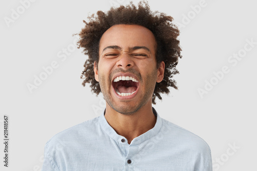 Photo Of Overjoyed Dark Skinned Mixed Race Male With Curly