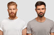 © WHstudio Leushin N - Bearded serious male friends with trendy haircut, stand close to each other, think where spend free time, dressed casually. Two stylish young men colleagues collaborate for creating common project