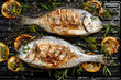 Grilled Dorada fish, sea bream with the addition of spices, herbs and lemon on the grill barbecue, top view