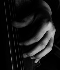 A classically trained musician plays cello, close up black and white