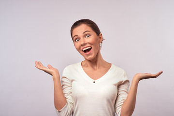 Wall Mural - Portrait of surprised excited woman screaming amazed in shock. Beautiful girl isolated on white background in casual white wear.