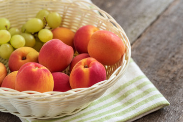 Wall Mural - Ripe sweet fresh apricots in a basket on the wooden table.