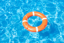 Summer Still Life With An Orange Lifebuoy On A Background Of Blue Water Pool