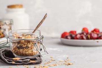 Wall Mural - Homemade oat granola in glass jars with cherry and yogurt. Healthy food concept.