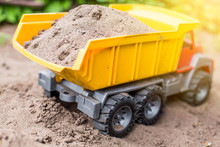 Children's Toy Truck With Sand. Concept Of Transportation Of Goods And Building Materials
