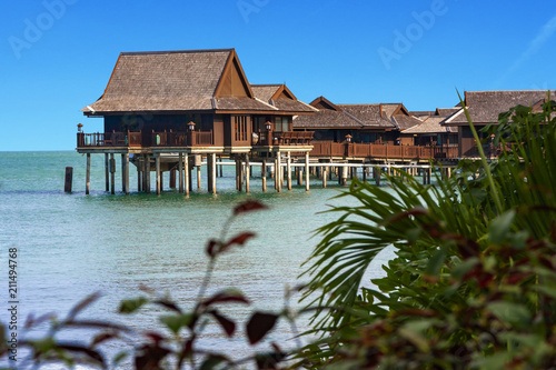 Wooden Cottages Bungalows On Clear Blue Water Waiting For