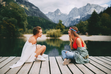 Wall Mural - Two young tourist women have fun on the lake