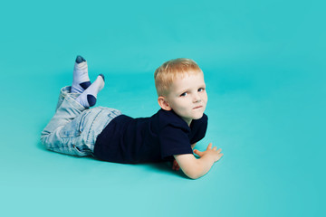 Portrait of a little boy. Lying on blue background