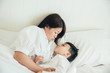 © ic36006 - Happy loving family. Mother and her son playing on the bed in bedroom.