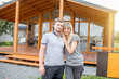 © rh2010 - Young and happy couple standing together outdoors near the wooden country house for sale