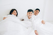 © ic36006 - Happy aian family lying in bed and sleeping.
