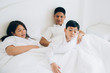 © ic36006 - Happy aian family lying in bed and sleeping.