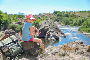 Wall Mural - little girl on rock near river. summer camp