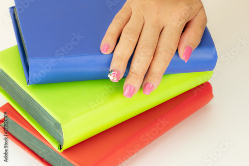 Closeup Of Beautiful Pink Nail Design At Female Hand At Stack Of