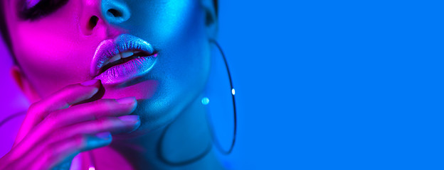 high fashion model woman in colorful bright neon lights posing in studio. beautiful sexy girl, trend