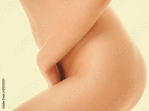 Fényképezés  Perfectly naked woman covering her vagin venter.