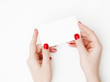 © looking2thesky - Flat lay, top view. Beauty and fashion concept. Beautiful female hands with red manicure. Minimal style. Minimalist photography. Pale composition with girl's hand holding card on white background
