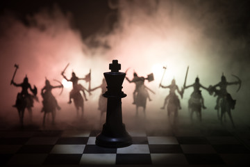 Medieval battle scene with cavalry and infantry on chessboard. Chess board game concept of business ideas and competition and strategy ideas Chess figures on a dark background. Selective focus