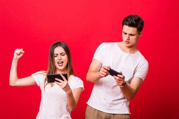 Sticker - Beautiful woman and handsome man with smart phones over red background