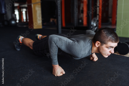 Fotografía A man doing push-UPS in the gym, sports, push-UPS on weights