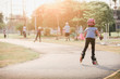 © jayzynism - Girl playing roller skates with friends outdoors.
