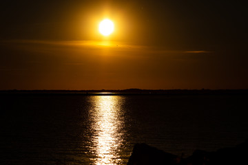 Wall Mural - Sunset on Lake with Shore Rocks