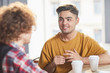 © pressmaster - Two young managers having drinks during discussion of working moments at meeting