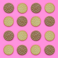 Pattern of a brown biscuits on a pink background. Trendy minimal concept of food and dessert. Abstract flat lay, top view