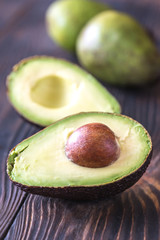 Poster - Halved avocado on the wooden background