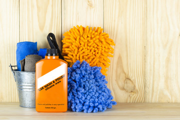 Car wash equipment or car cleaning product such as   brush with mitts and microfiber tank and  etc, on wooden table.