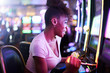 woman having fun playing slot machine at casino