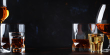 Set Of Strong Alcoholic Drinks In Glasses And Shot Glass In Assortent: Vodka, Rum, Cognac, Tequila, Brandy And Whiskey. Dark Vintage Background, Selective Focus