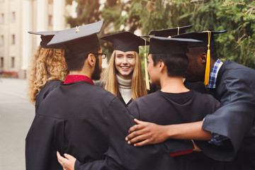 Poster - Graduates having group hug on graduation day